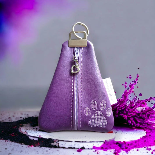 Purple paw themed triangle shaped vinyl coin purse with zipper and heart shaped zipper pull with a splash of colour background.